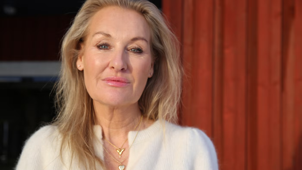 Pressbild på Jessica MacDowall i vit tröja med röd bakgrund