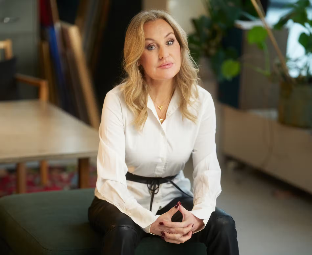 Jessica MacDowall på en sittpuff med vit skjorta